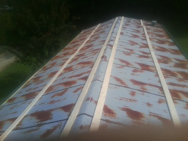 Rusted metal roof panels with new wood purlins before replacement — Storm Damage Roof Repair in Peachtree City by Roofing Brothers