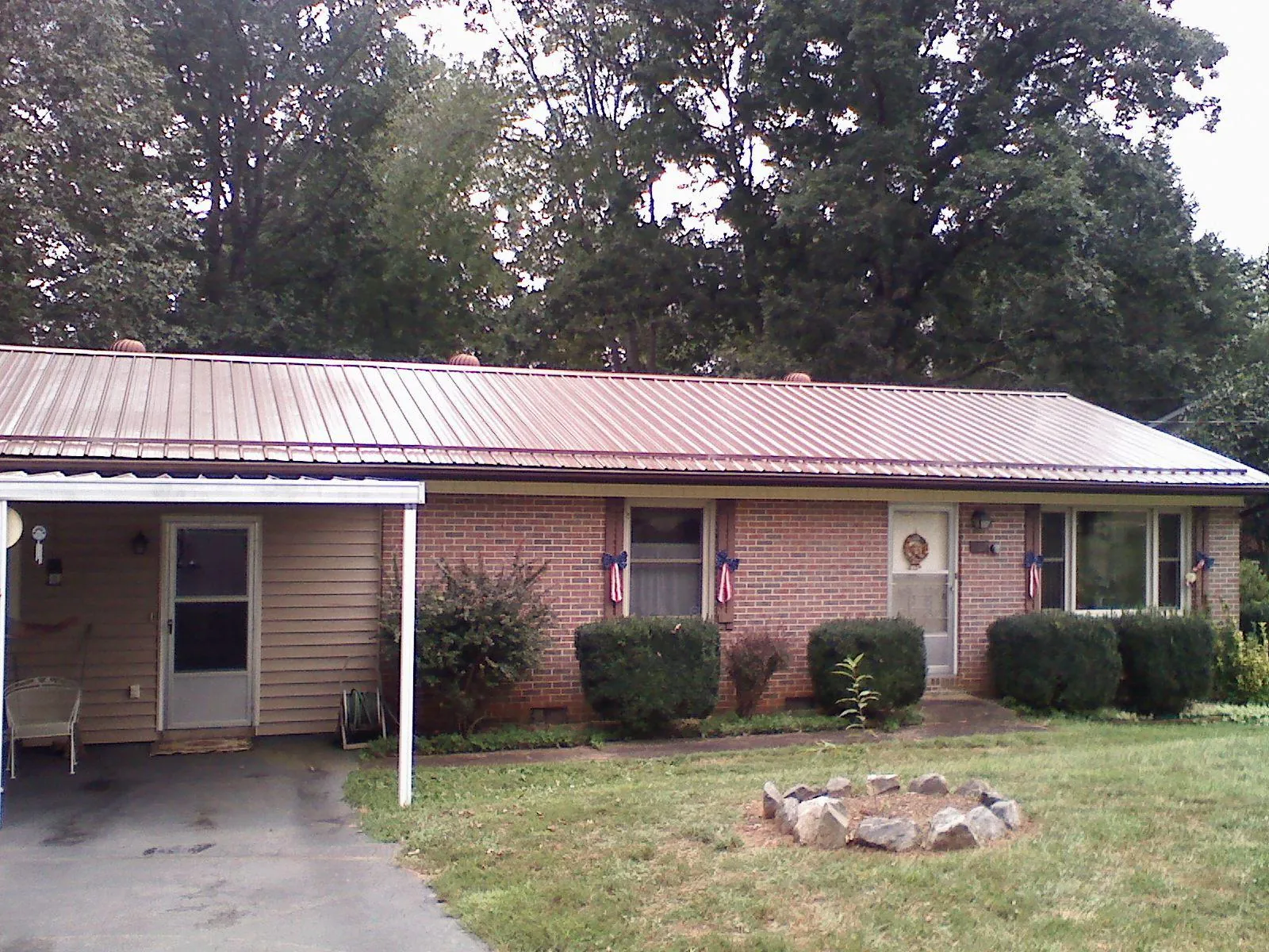 Bronze metal roof and carport on a brick ranch home — Roof Repair work by our crew in Peachtree City